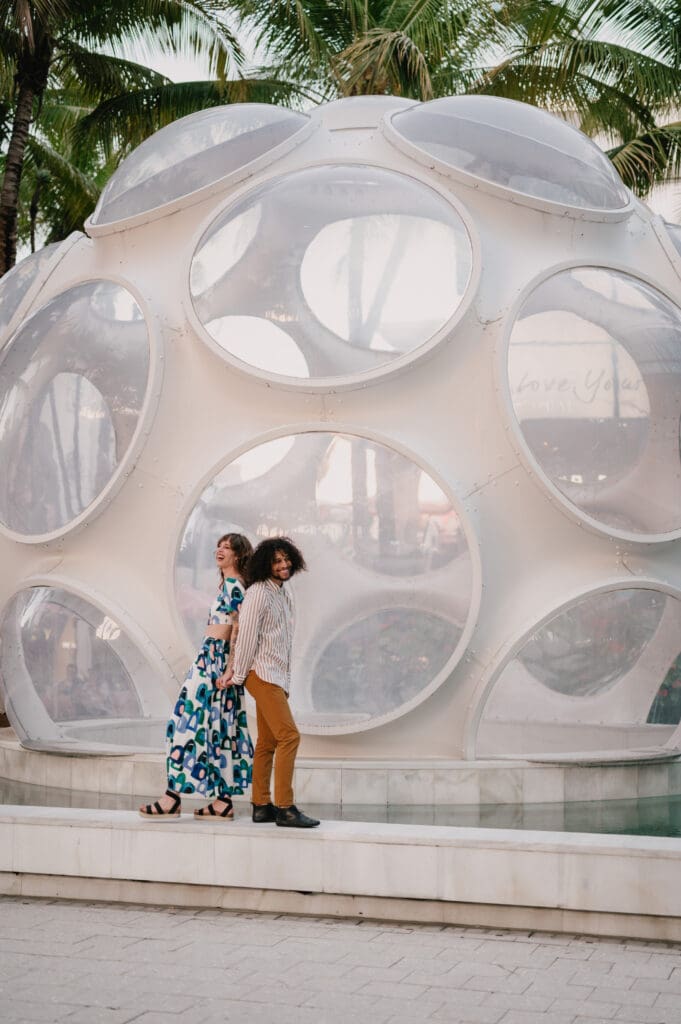 Couple photoshoot in Miami Design District, standing in front of the iconic geodesic dome with modern architecture and palm trees