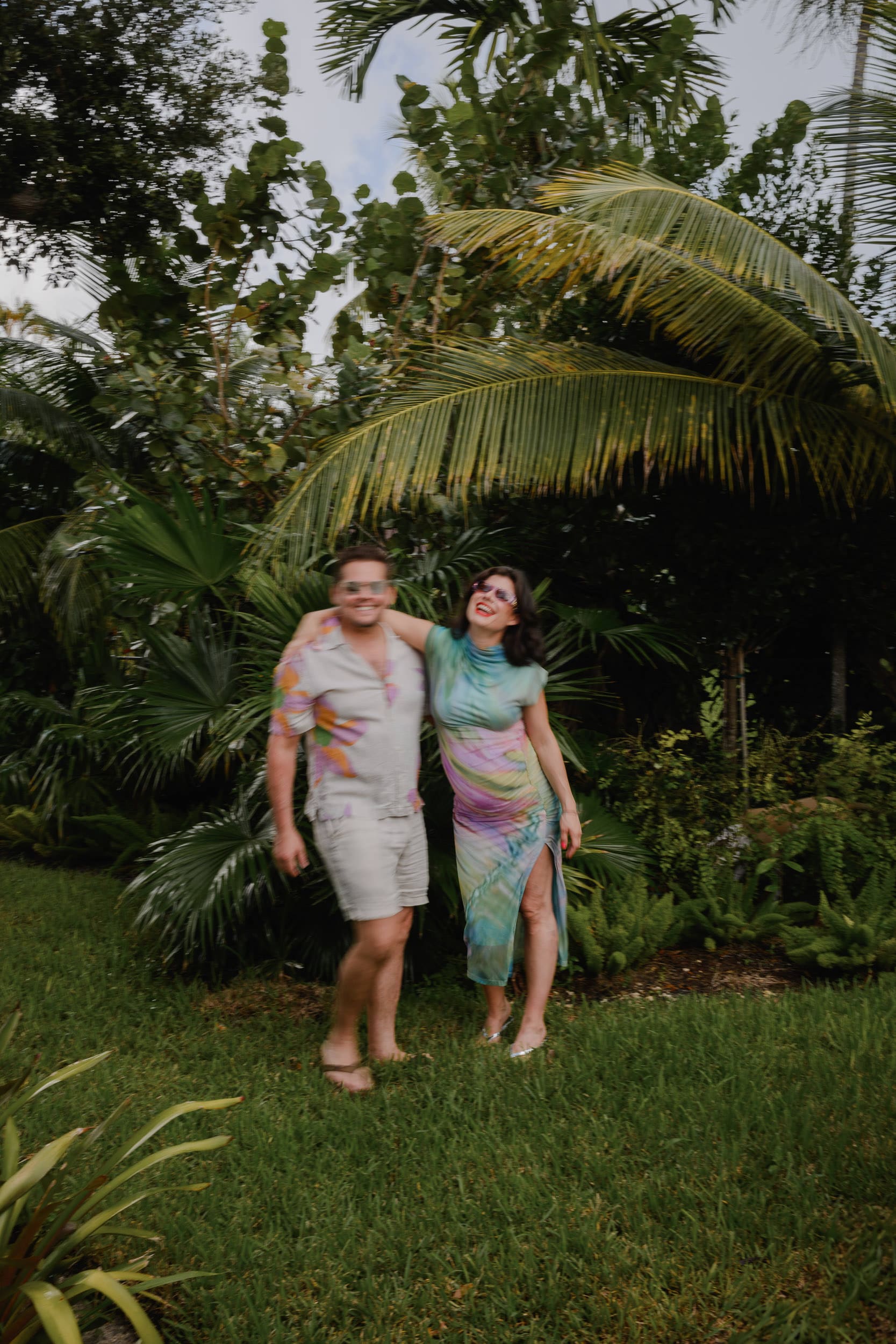 Luci and Alex standing together in their North Miami backyard during their at-home maternity session, photographed by Carolina Menendez Photo.
