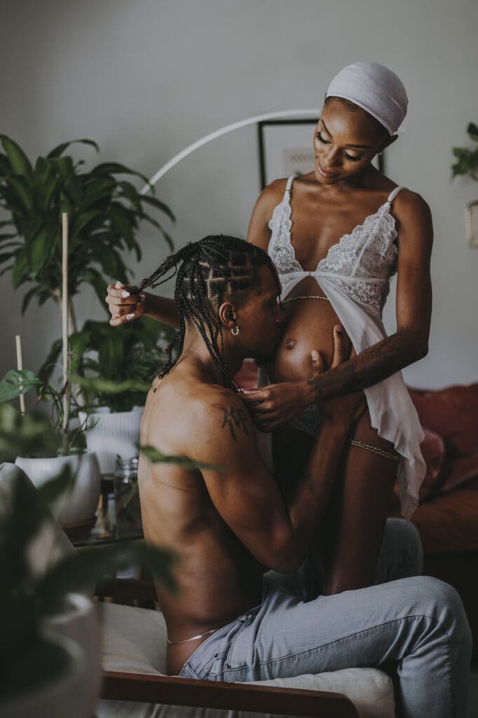 In home maternity session with an expecting couple sharing a quiet moment indoors, photographed in natural light