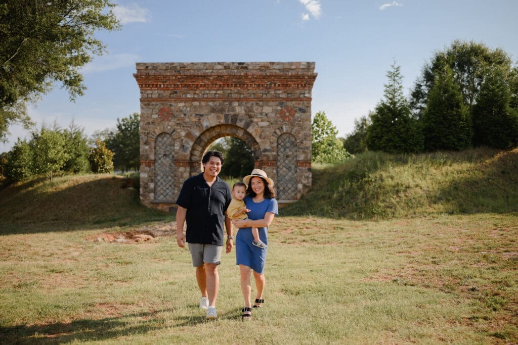 Family walking in front of the historic stone arch at BridgeWay Station during a family photography session in Greenville, South Carolina.