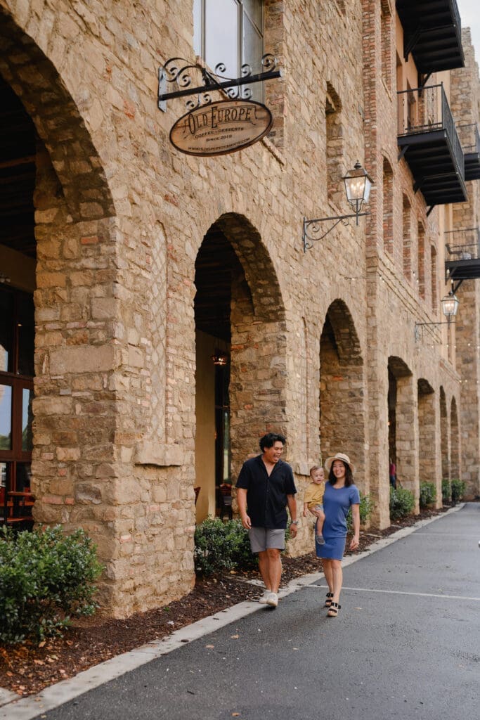 Family walking beneath the stone archways at BridgeWay Station during a family photography session in Greenville, South Carolina.