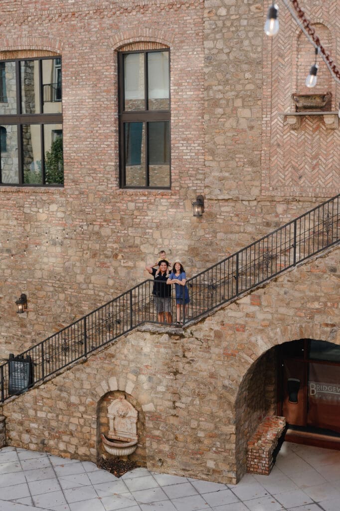 Family standing on the stone staircase at BridgeWay Station during a family photography session in Greenville, South Carolina.