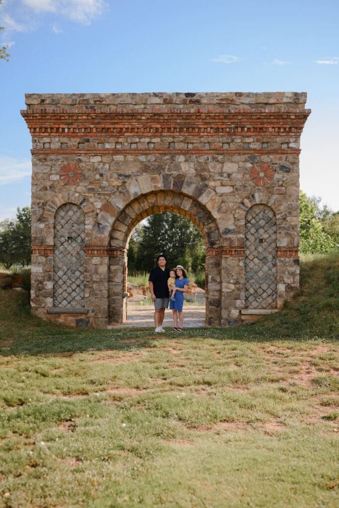     Family portrait beneath the stone archway at BridgeWay Station